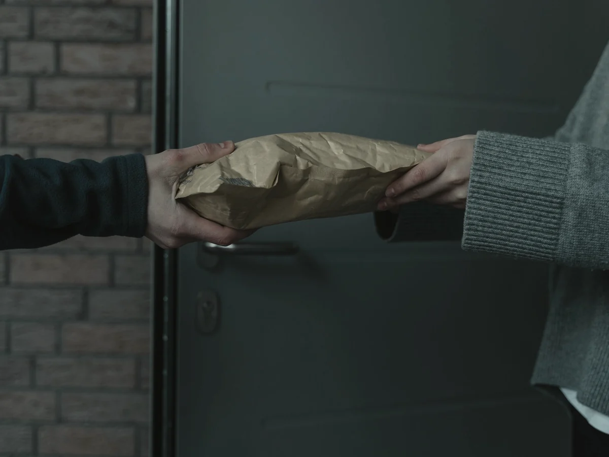 Parcel handed from courier to recipient at a front door